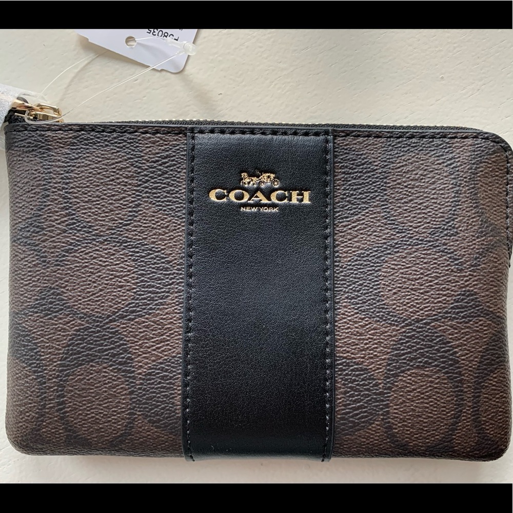 Coach corner zip wristlet in signature canvas.